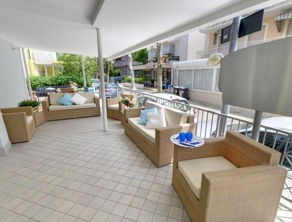 里乔内马雷欧公寓酒店的大楼内的阳台配有椅子和遮阳伞