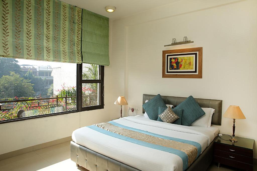 古尔冈Ahuja Residency Parklane, Gurgaon的一间卧室设有一张大床和一个窗户。