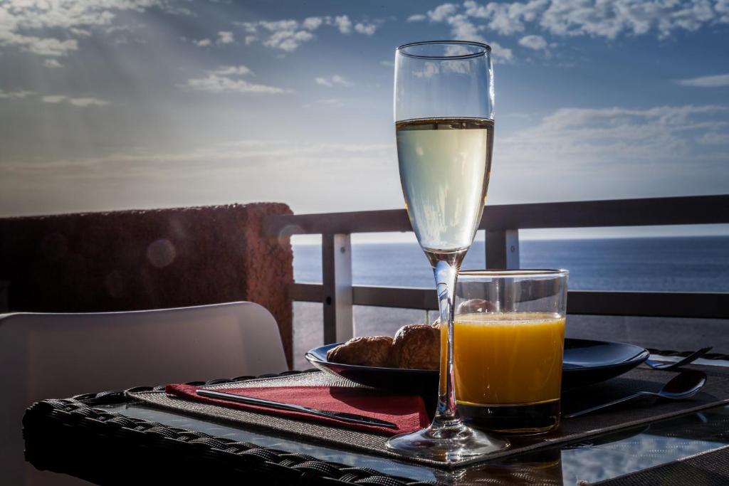 蓬塔德尔西达尔戈Sunset on the sea的一杯葡萄酒和一盘桌上的食物