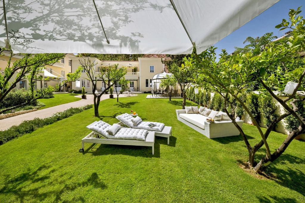 卡利亚里芬妮别墅酒店的绿色草坪上两张白色沙发