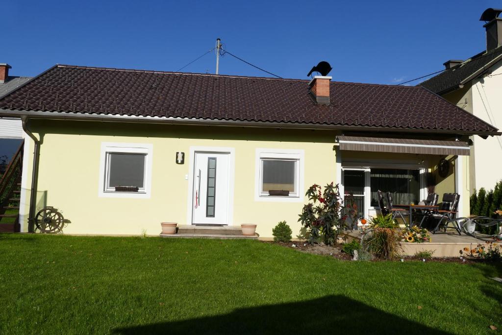 博登斯多夫Ferienwohnung Stichauner的一座小黄色房子,有草地庭院