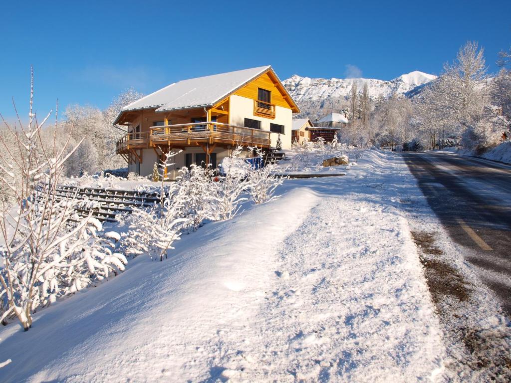 圣米舍德谢洛Au Chant du Riou的雪覆盖在雪覆盖的路上的房子