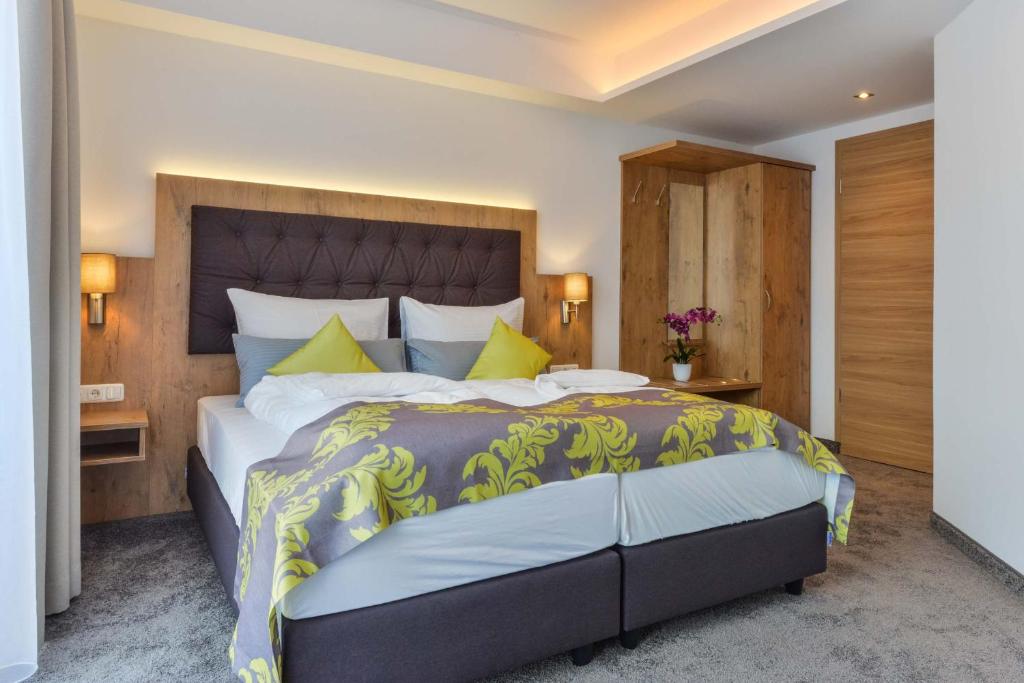 奥格斯堡Hotel Haunstetter Hof Augsburg的一间卧室配有一张带黄色枕头的大床
