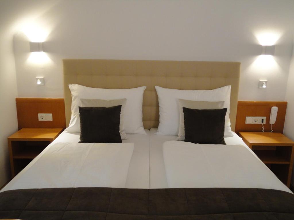 施韦夏特阿尔布切特城市酒店的一间卧室配有一张大床和两个枕头