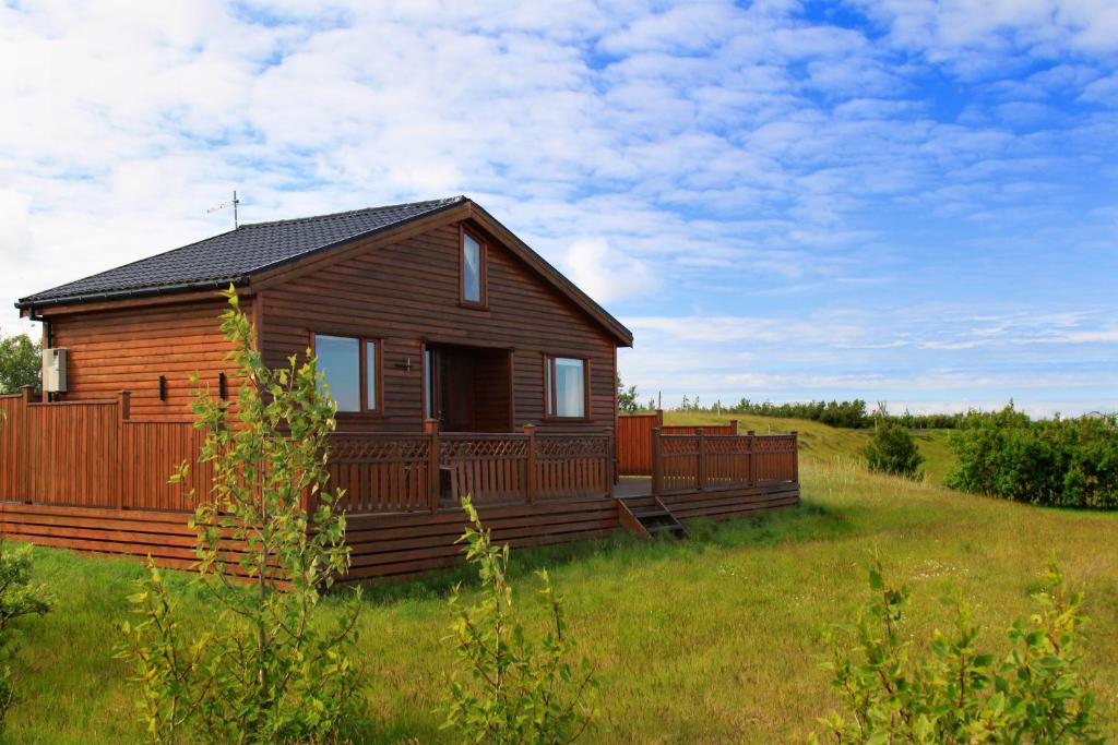 霍尔斯沃德吕尔Cozy Cottage by Stay Iceland的绿色田野中的小木屋