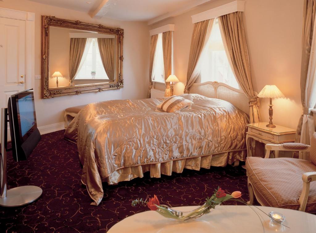 克里斯蒂安斯费尔德Tyrstrup Kro的酒店客房,配有床和镜子