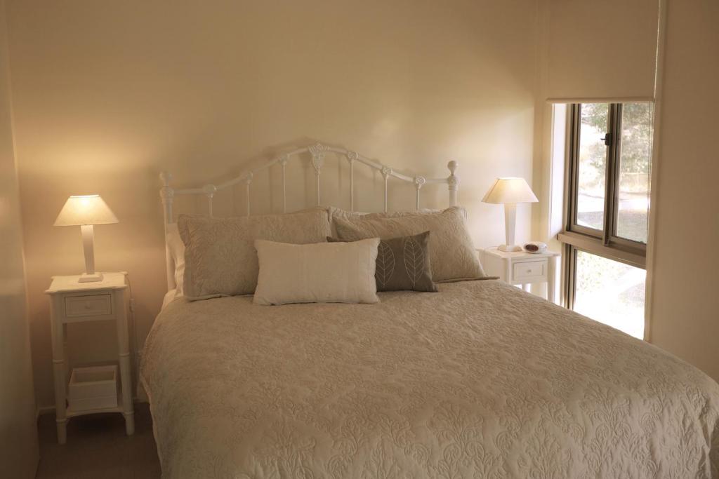 Nyora小湖小屋住宿加早餐旅馆的一间卧室配有一张带2个床头柜的大床