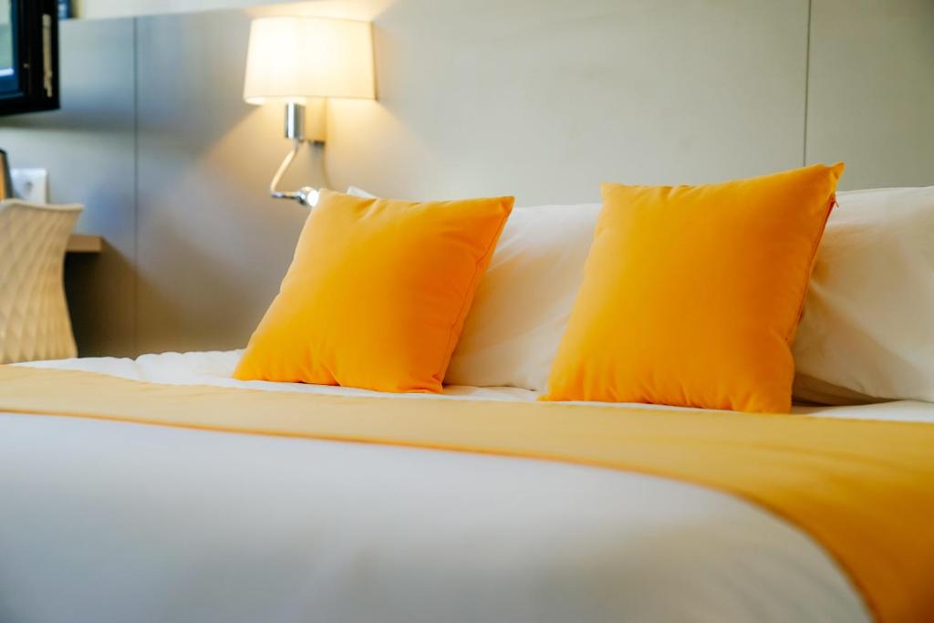 龙克Kyriad Lille - Roncq的床上有两个橙色枕头