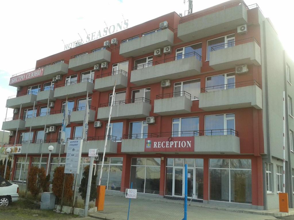 阳光海滩Hotel Seasons 2的前面有酒店标志的红色建筑