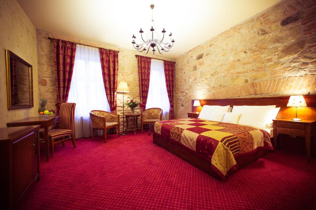 比尔森劳斯酒店的酒店客房带一张床、一张桌子和椅子
