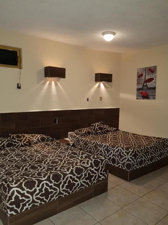 阿卡普尔科Costa Miramar的两张睡床彼此相邻,位于一个房间里