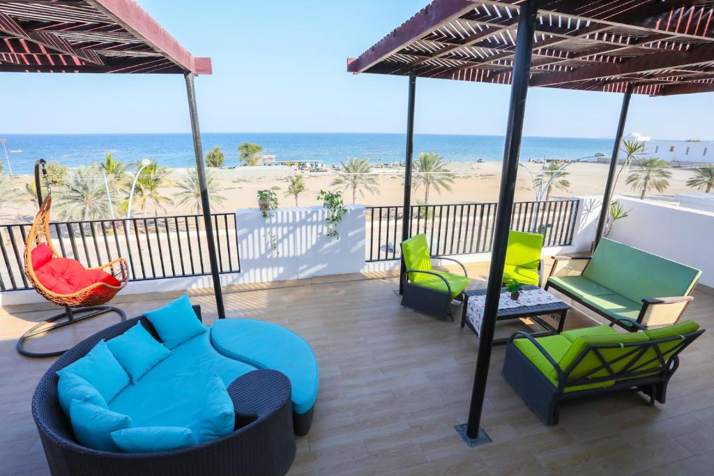 马斯喀特Lana Villa的一个带椅子和遮阳伞的庭院和海滩