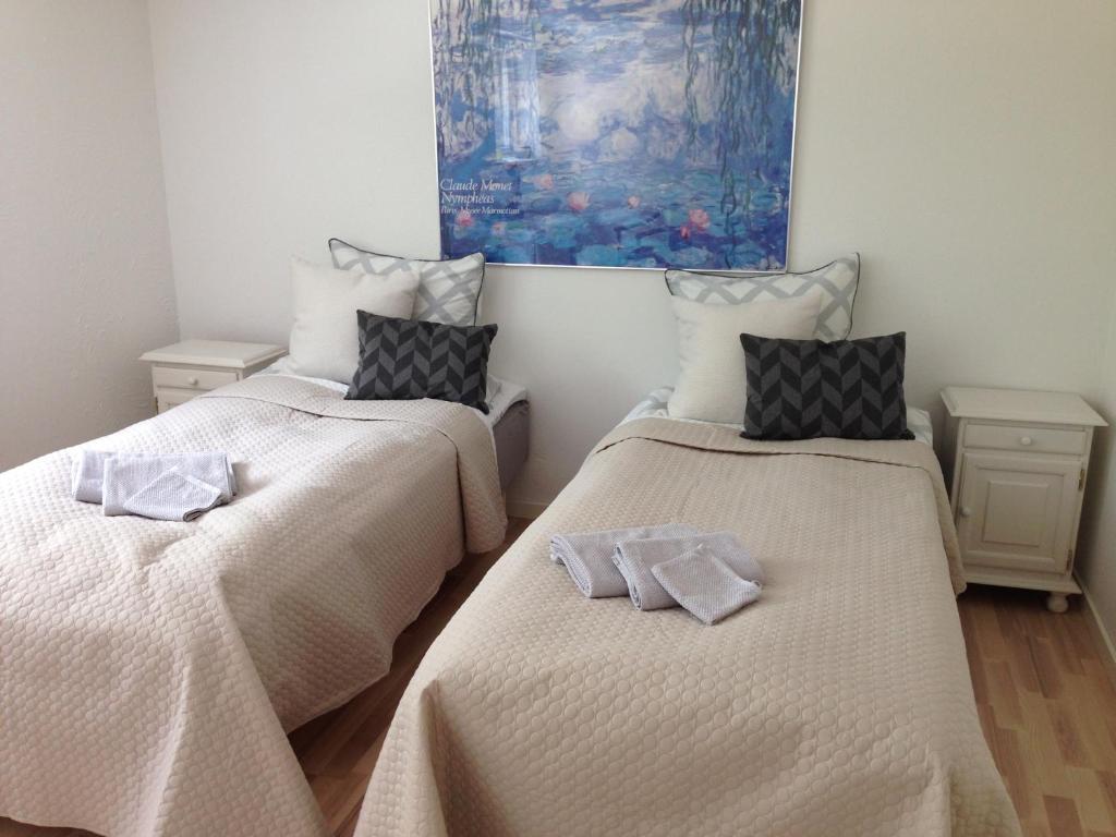 KjellerupLundgaarde Bed & Breakfast的客房内的两张床和毛巾