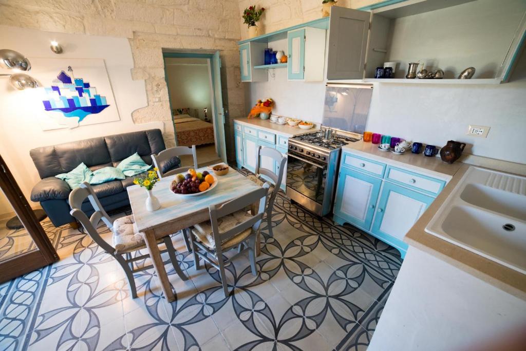 奥斯图尼Casa del Sud的厨房配有蓝色橱柜和水果桌