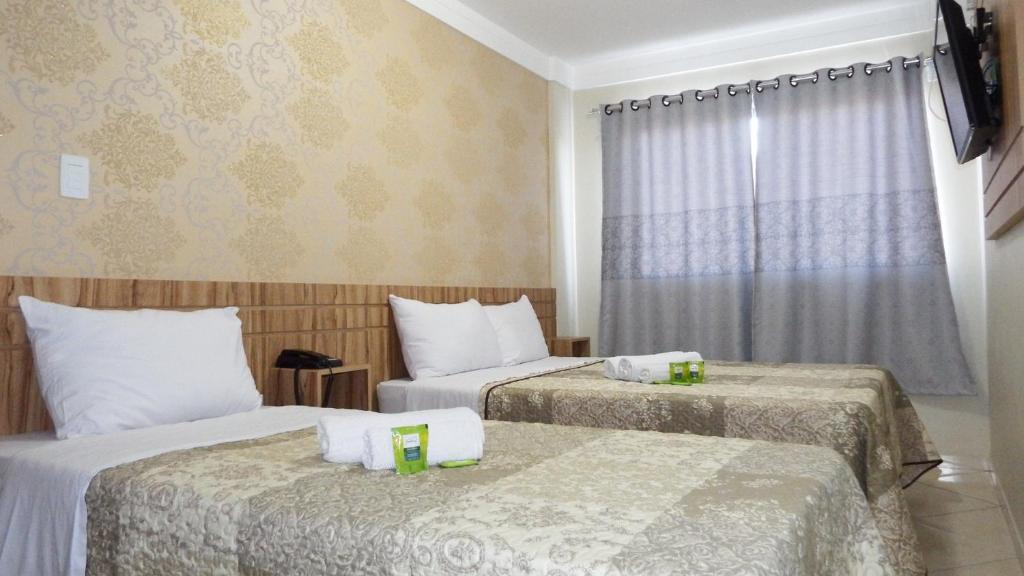 SangãoCoral Palace Hotel的酒店客房设有两张床和窗户。