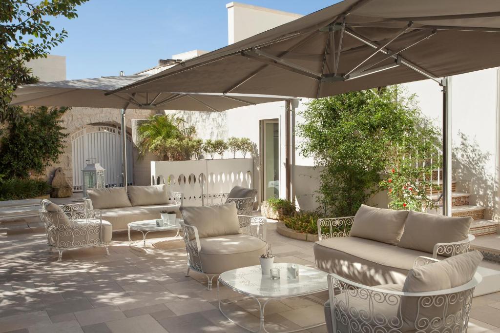 莱切曼塔特鲁尔酒店的一个带沙发和桌子及遮阳伞的庭院
