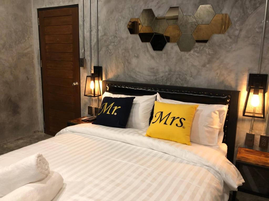 查汶黑杰克酒吧旅舍的一间卧室配有一张带黄色枕头的大床