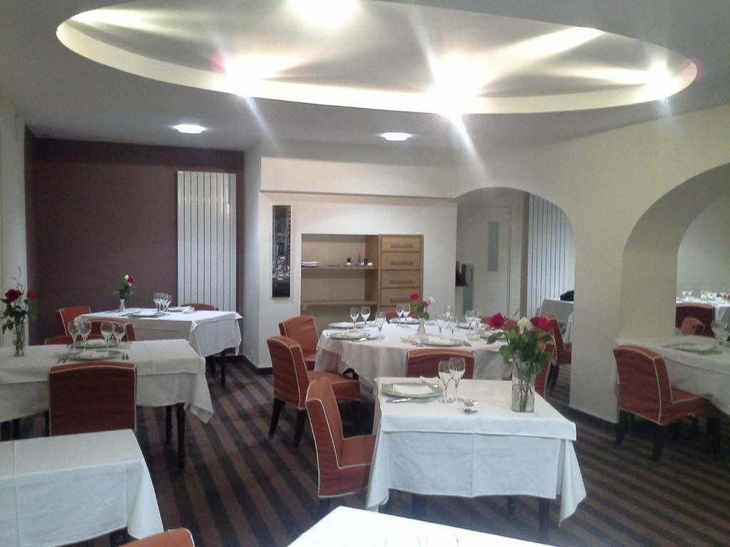 Noyal-sur-VilaineHotel les forges的一间设有白色桌椅的用餐室