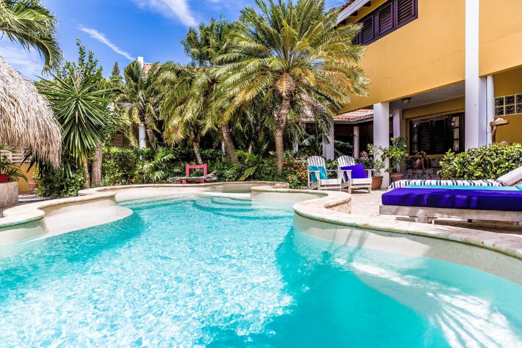 克拉伦代克海景别墅的一个带蓝色椅子的游泳池,棕榈树