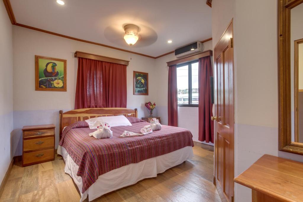 圣伊格纳西奥维纳斯酒店的一间卧室配有一张床,上面放着两只猫
