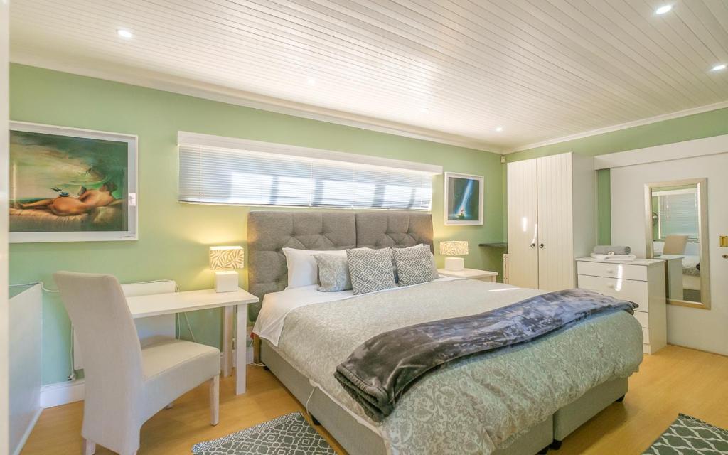 开普敦Inn-Style的一间卧室配有一张床、一张书桌和一个窗户。