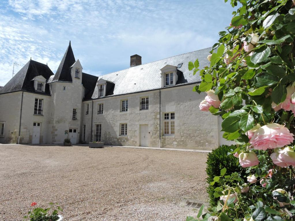 Mareuil-sur-CherEmbarcadere ou Ecluse的一座白色的大建筑,上面有一堆粉红色的玫瑰