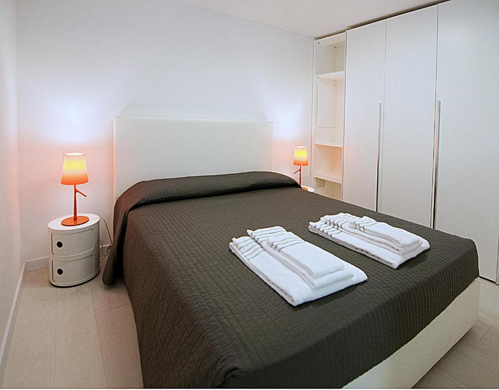 米兰德苏伊特BB酒店公寓式酒店的一间卧室配有一张床,上面有两条毛巾