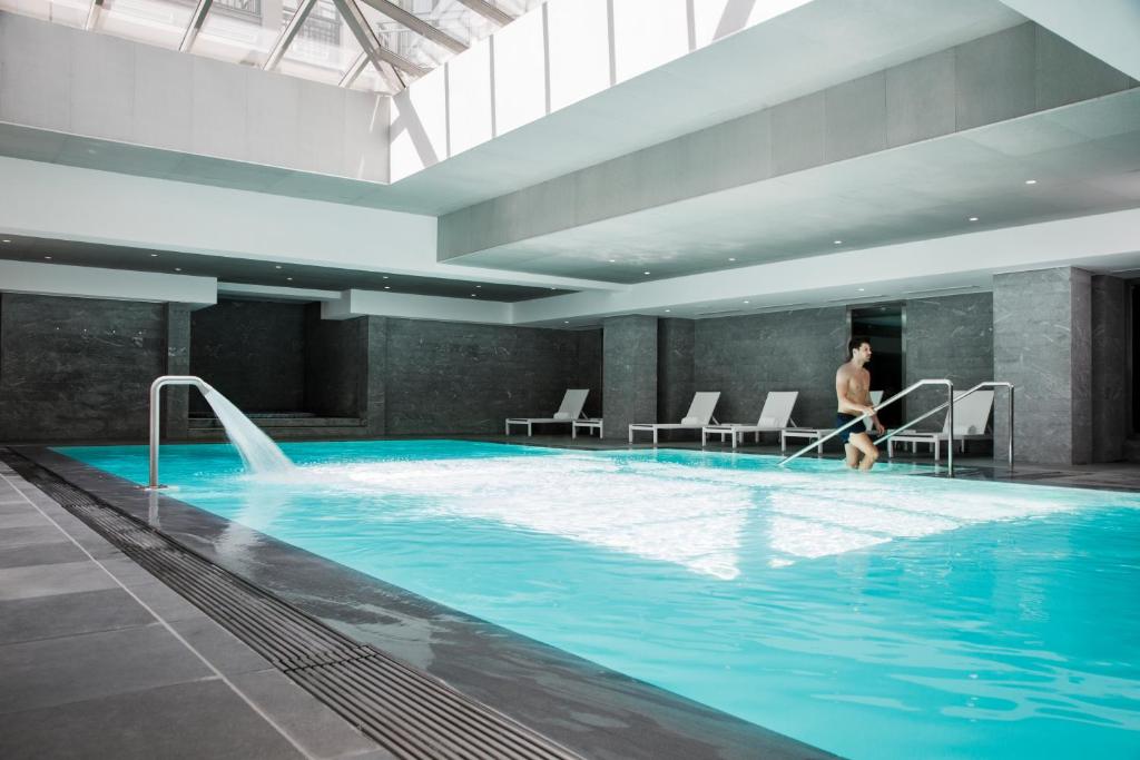 谢西雷拉斯Spa谢尔西瓦尔多欧洲酒店的一个人在大型游泳池里散步