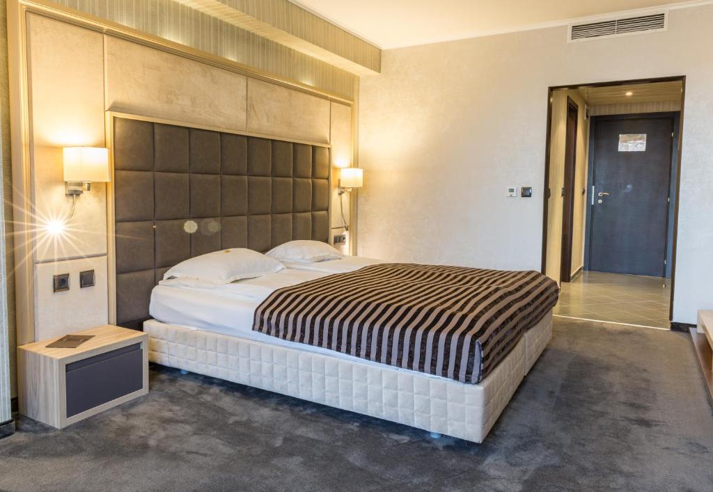 鲁塞丽都疗养酒店 的一间卧室配有一张大床和大床头板