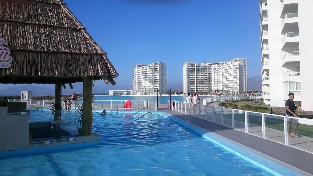拉塞雷纳Departamento La Serena Laguna del Mar的一座游泳池,里面的人和建筑物