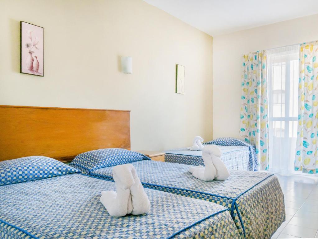 圣保罗湾城卡拉假日情结酒店的卧室内的两张床,里面放着动物