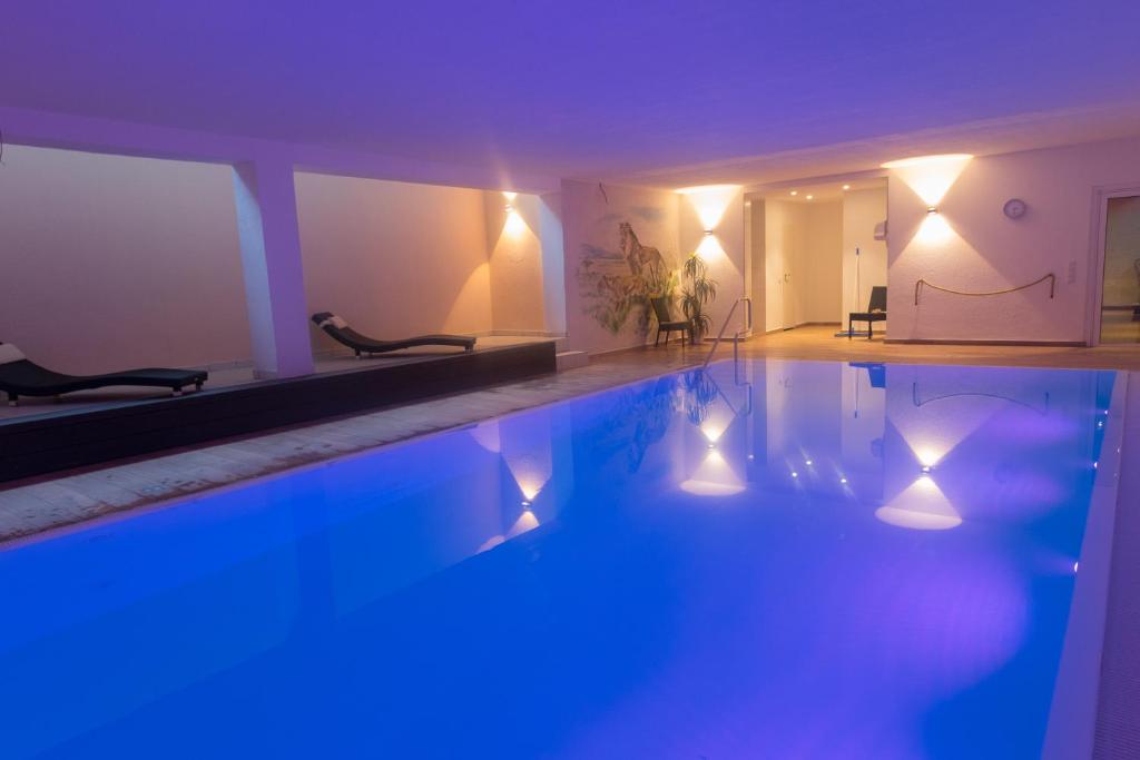 默费尔登-瓦尔多夫祖姆洛恩酒店的室内的游泳池,有蓝色的灯光