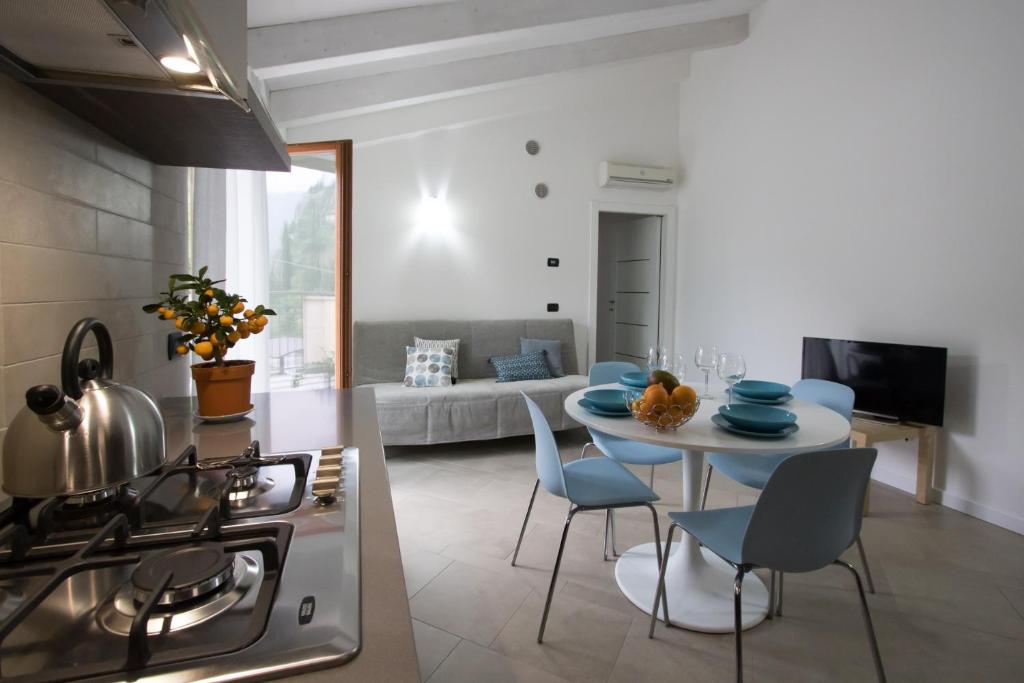 阿科Appartamento Il Soffio的厨房以及带桌椅的起居室。