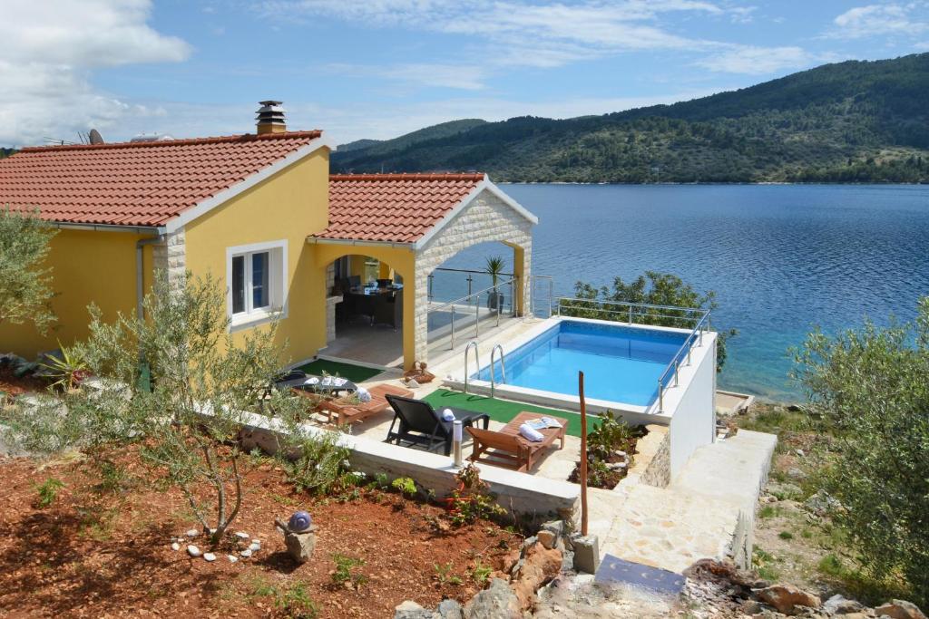 尼亚卢卡Villa Šeparović的水边的一座房子,有一个游泳池