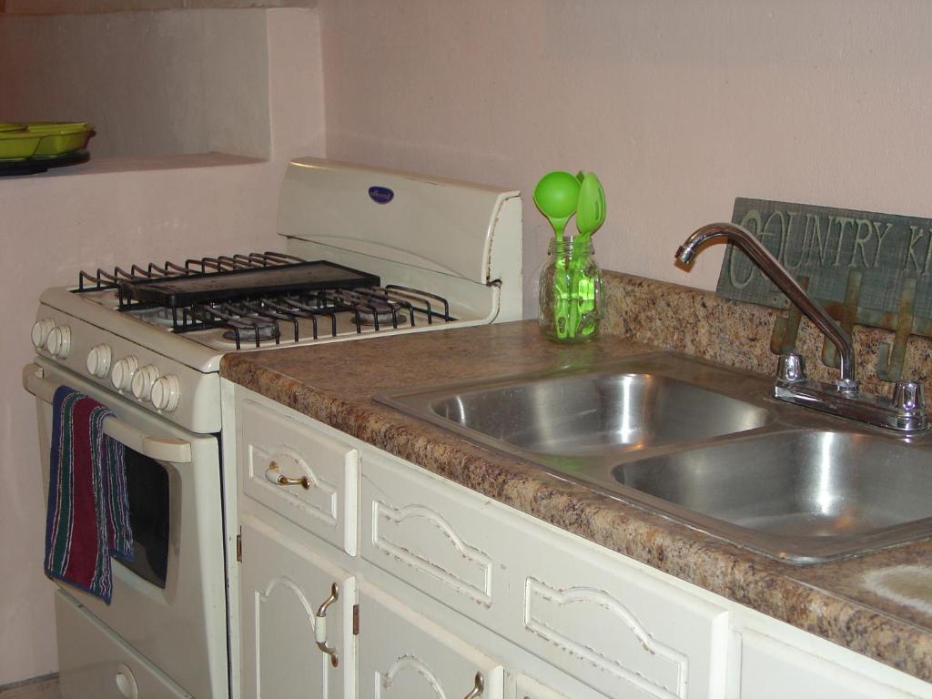 佩尼亚斯科港Sunset Apartment的厨房配有水槽和炉灶 顶部烤箱