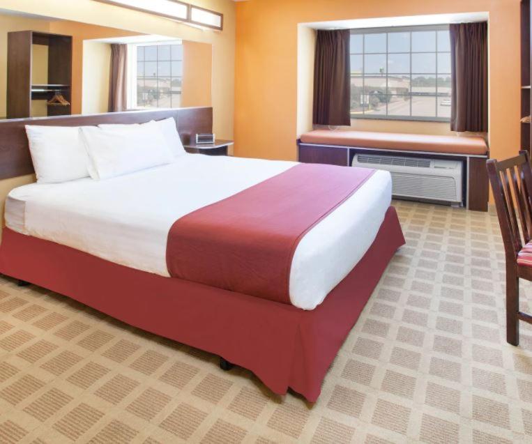 斯蒂尔沃特Microtel Inn by Wyndham Stillwater的一间设有大床和窗户的酒店客房