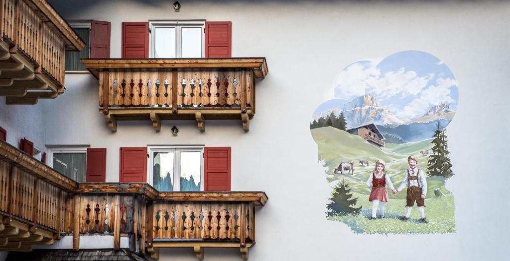 坎皮泰洛迪法萨Garni Tyrolia的带阳台的建筑和侧面的绘画