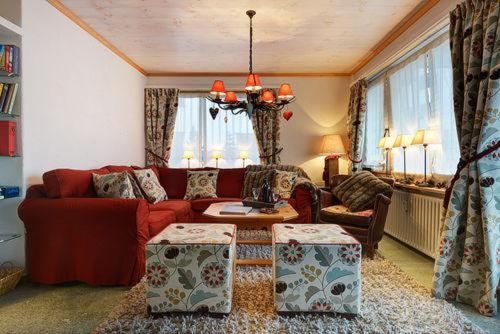 克洛斯特斯瑟纽斯Chalet Drusa的客厅配有红色的沙发和桌子