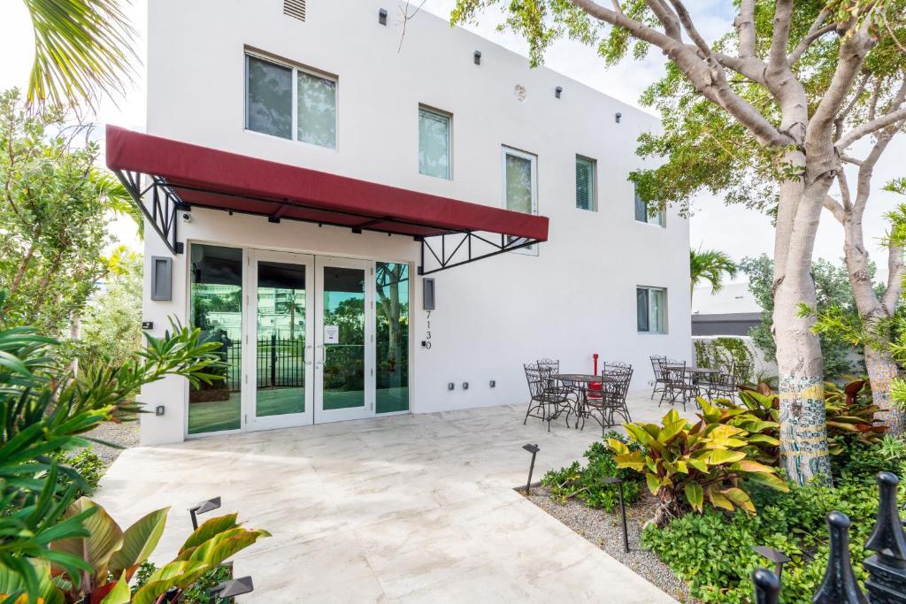 迈阿密海滩哥斯达黎加北精品酒店的白色的房子,设有配有桌椅的庭院