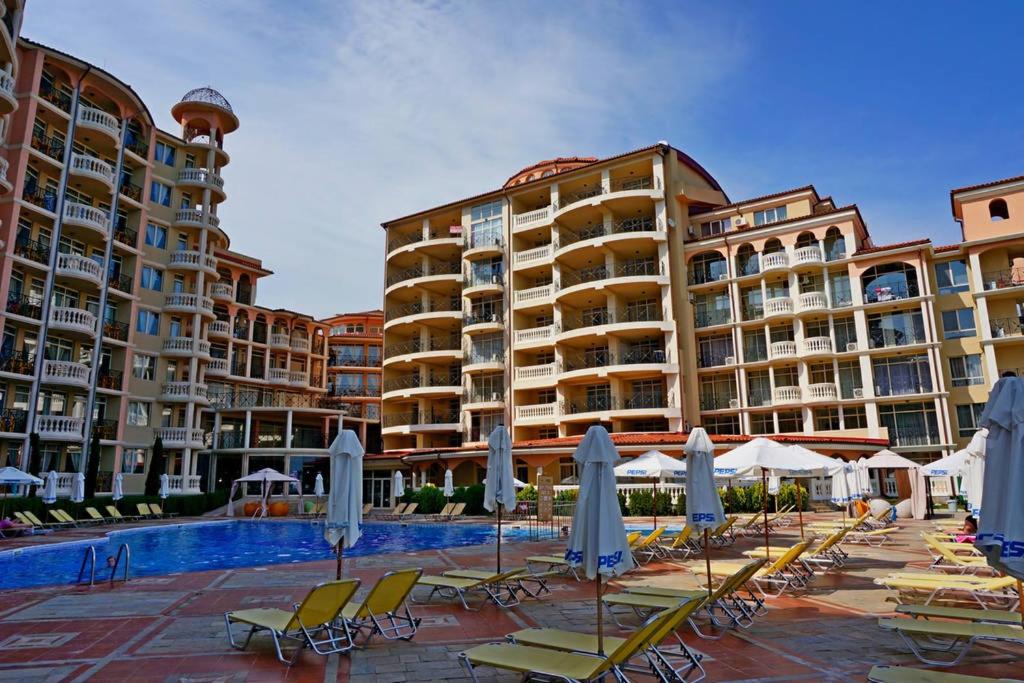 埃勒尼特Andalusia 2 Apartments的一个带游泳池、椅子和遮阳伞的度假村
