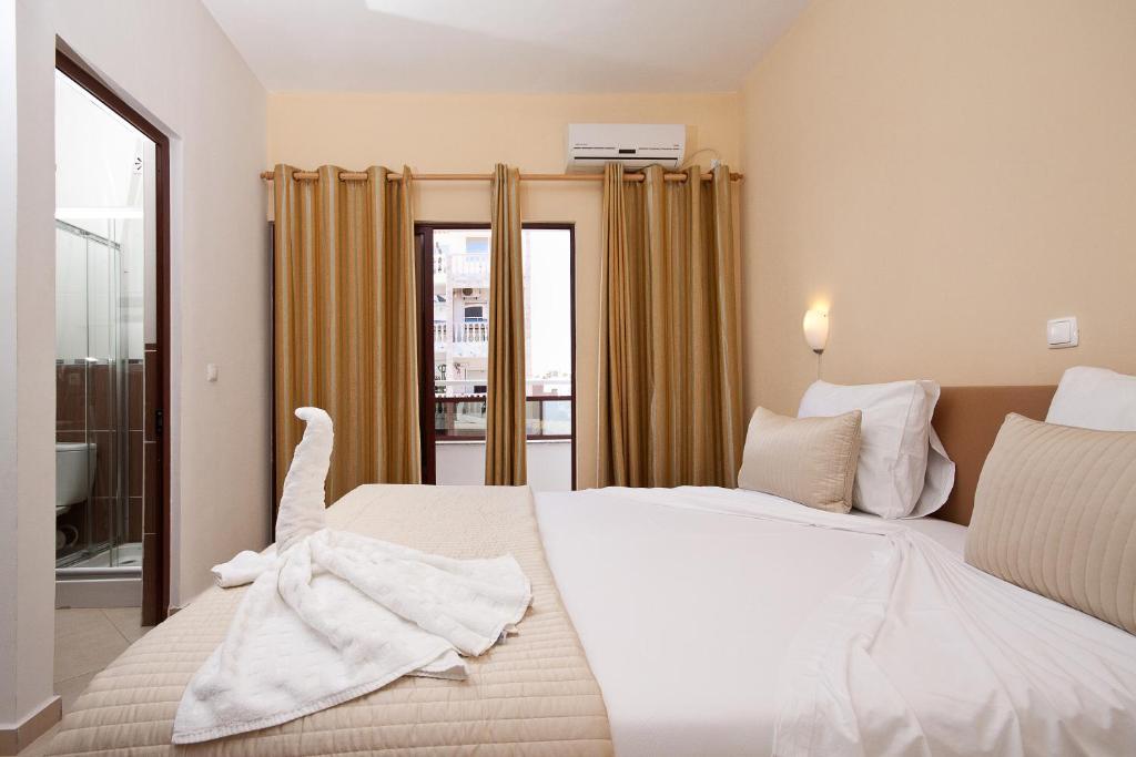 普拉亚普莱伊亚诺公寓酒店的卧室设有一张白色大床和一扇窗户。