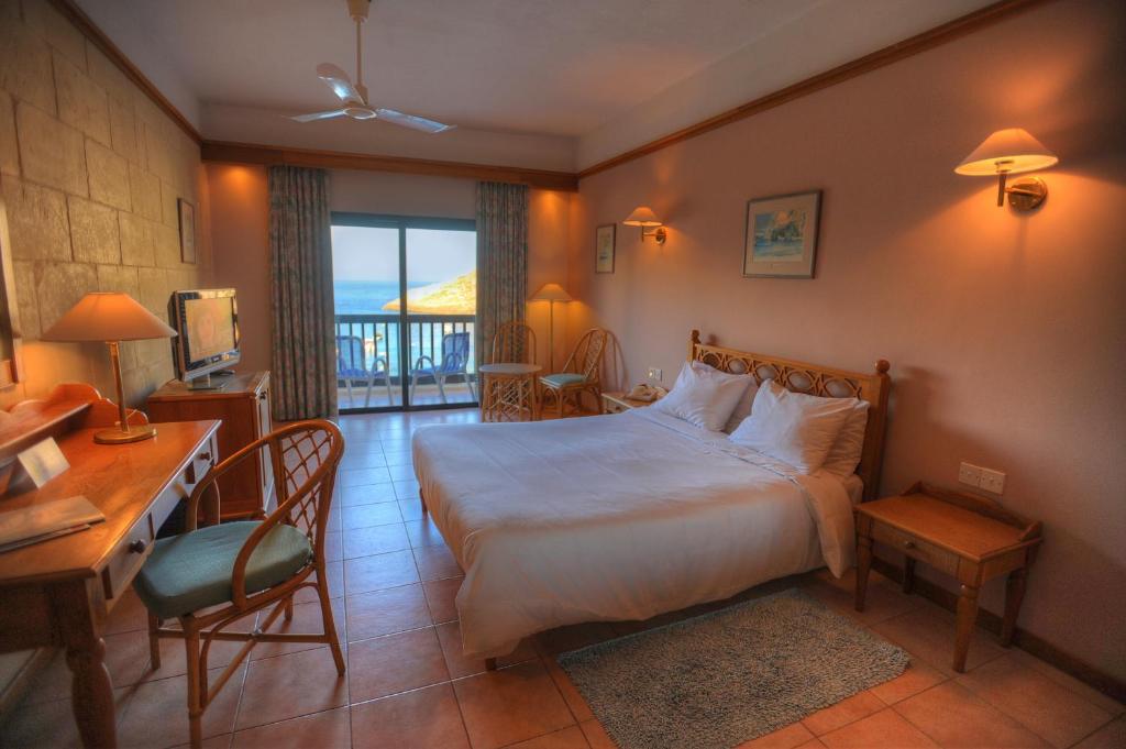 克伦蒂圣帕特里克酒店的酒店客房配有一张床、一张书桌和一张书桌。