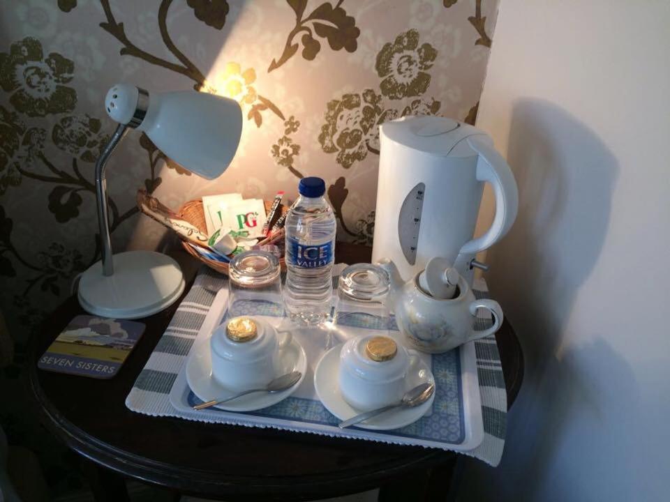 伊斯特布恩比奇莱丝酒店的茶壶、茶杯和台灯的桌子