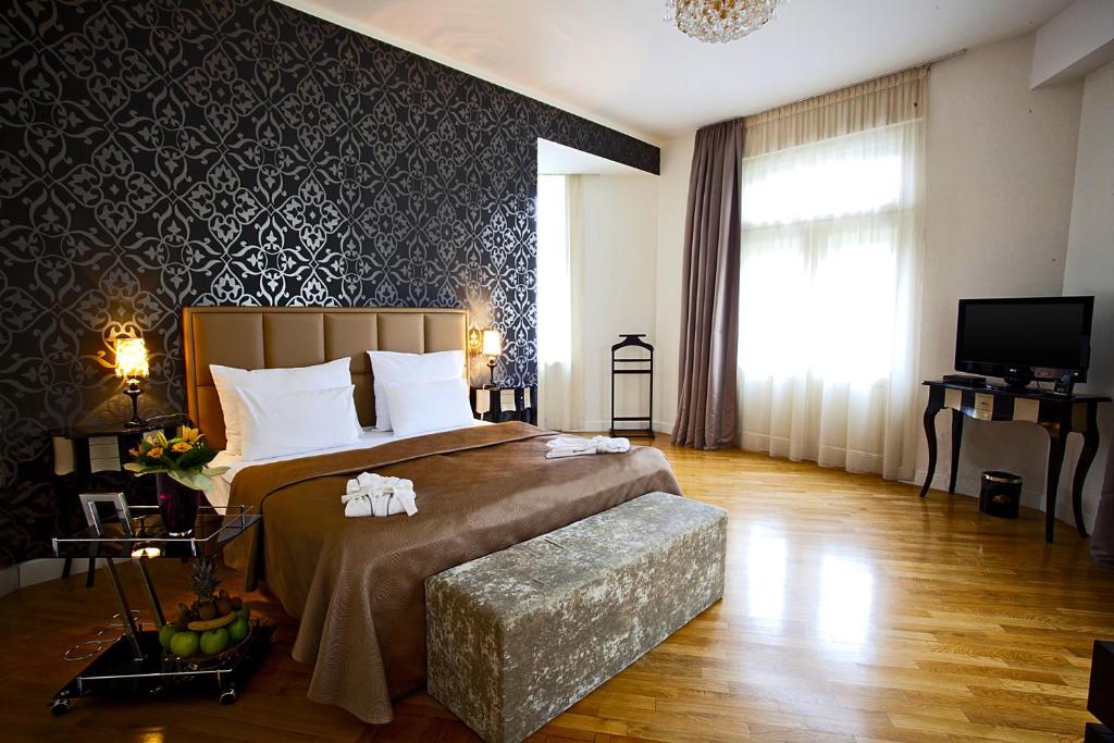 布拉格德米卡宫殿酒店的一间卧室配有一张大床和电视