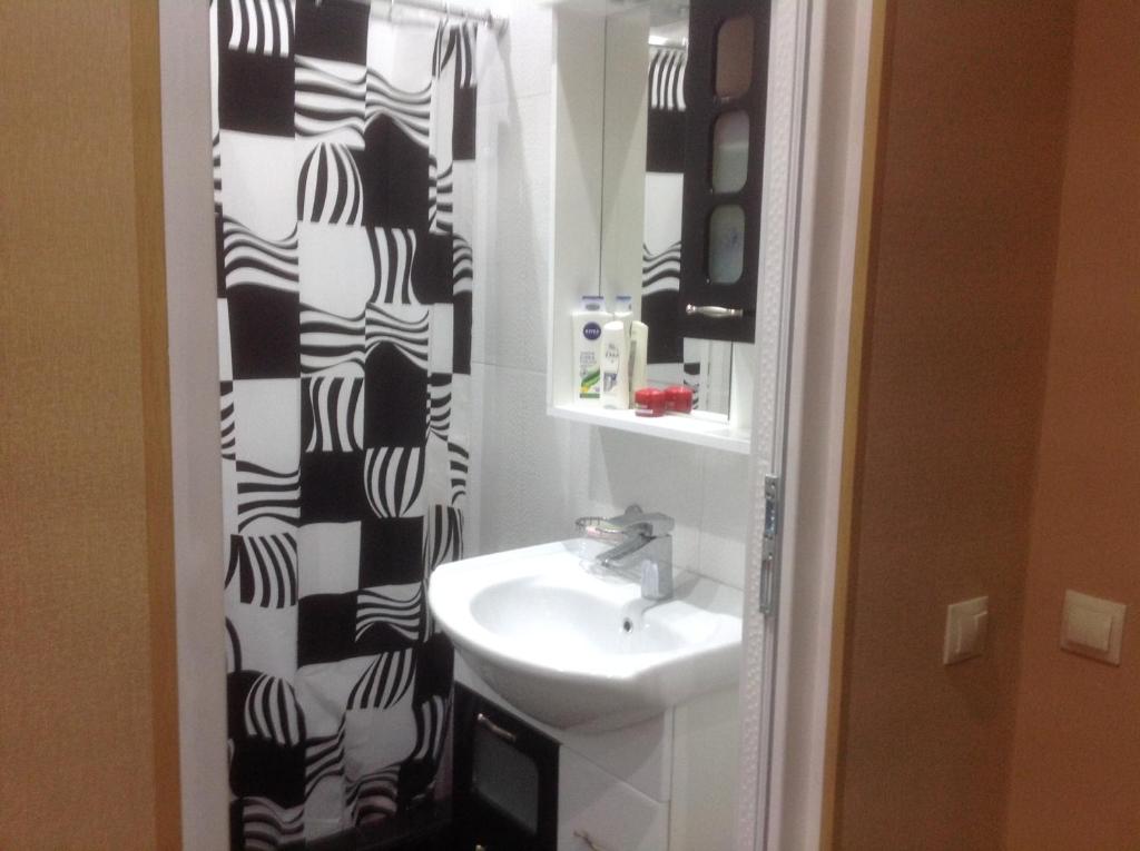 科布列季Comfortable Apartment near the Sea的浴室设有水槽和黑白淋浴帘。
