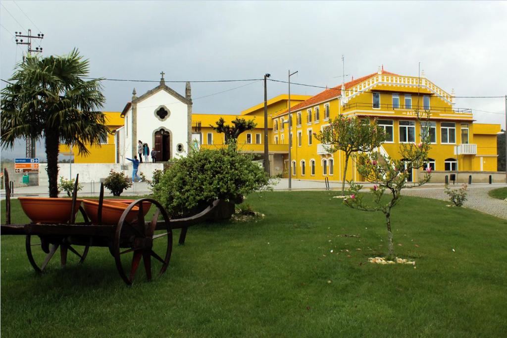 CarvalhalPalace Hotel Astúrias & Spa的草木上的公园,有建筑物