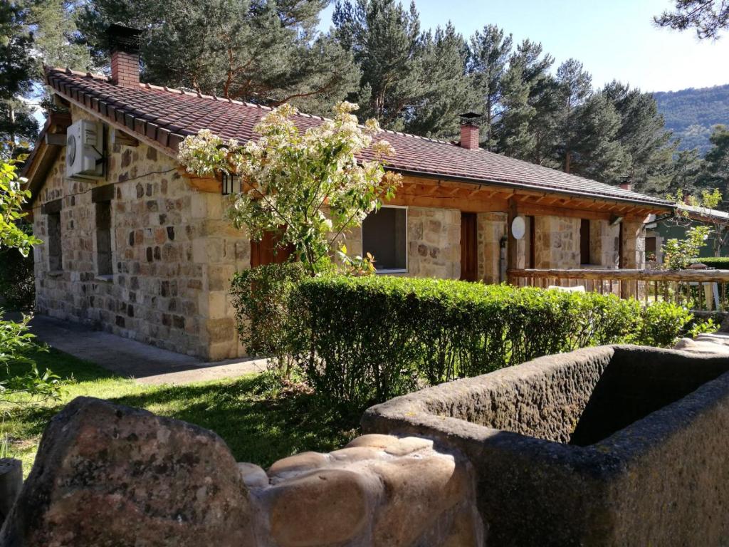 比努埃萨Los Ranchales Vinuesa的一座石头房子,前面设有花园