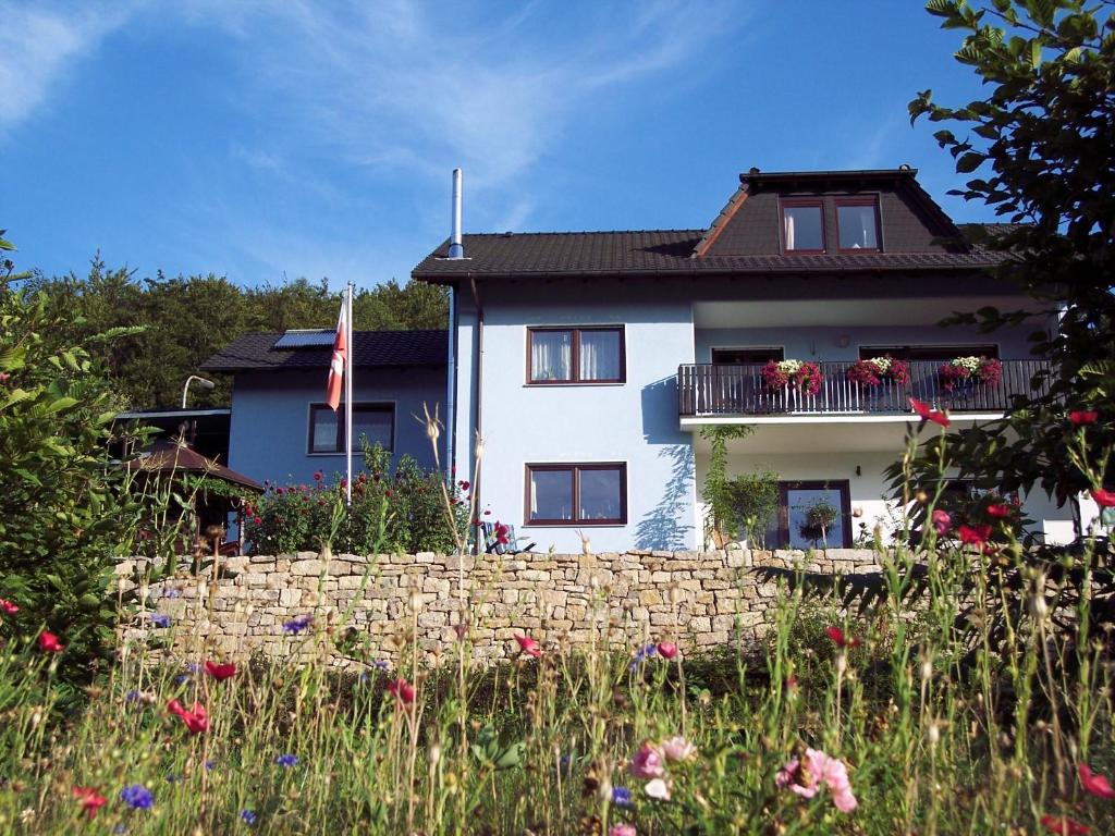 格明登Ferienwohnung Patricia Schipper的白色的房子,有栅栏和鲜花