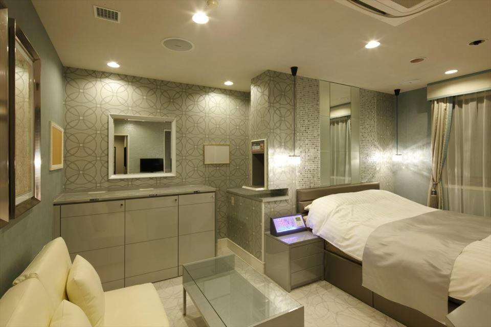 冈崎市华尔兹冈崎酒店（仅限成人） 的一间卧室配有一张床和一张桌子上的笔记本电脑