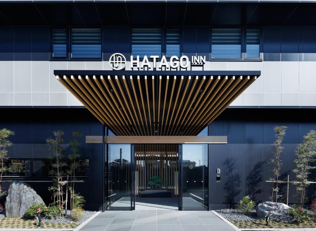 泉佐野HATAGO INN Kansai Airport的建筑物入口,上面有标志